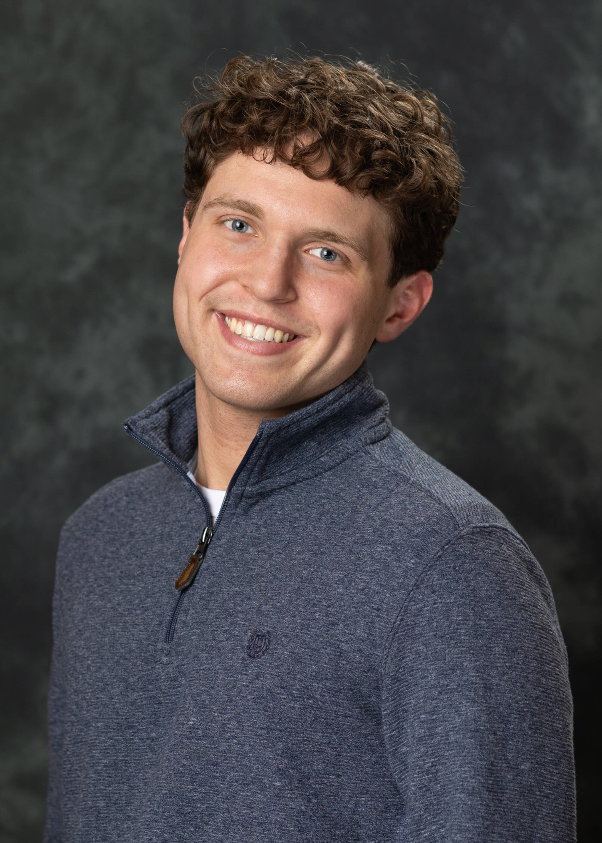 Ty Vanlerberghe smiling in a gray quarter-zip